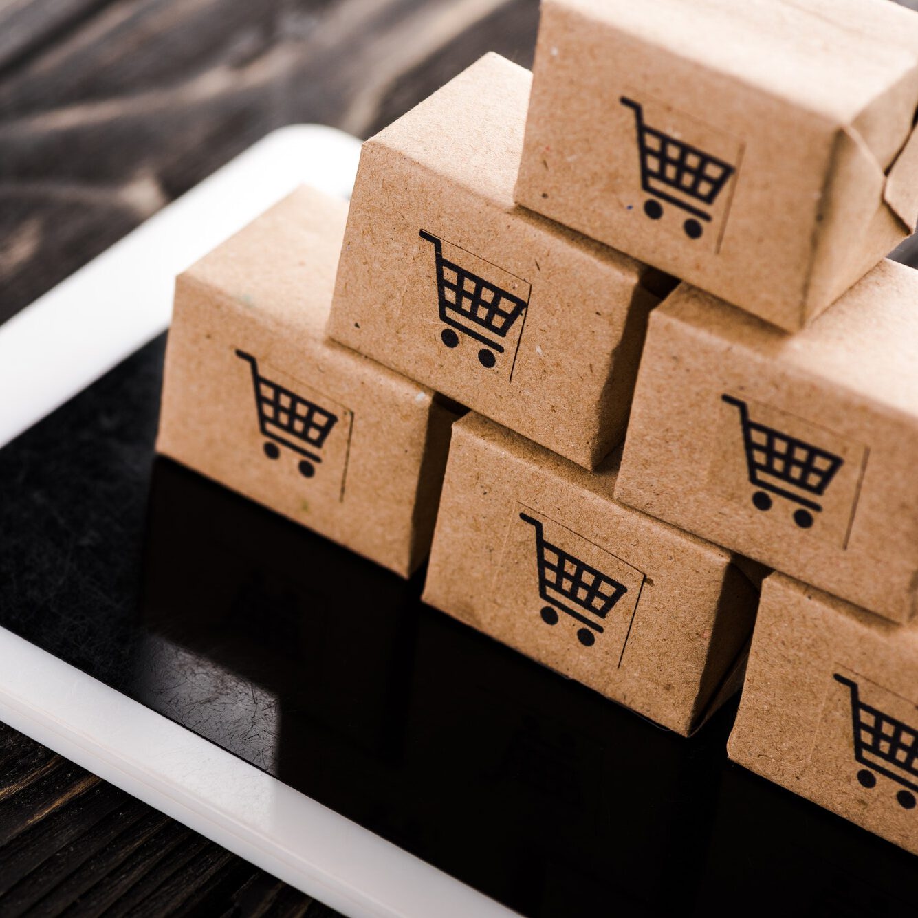selective focus of small carton boxes on digital tablet, e-commerce concept